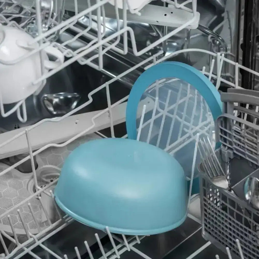 A light blue plastic bowl resting in a dishwasher rack from mepal cirqula deep bowl nordic white set of 3
