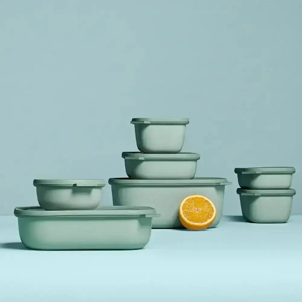 Set of green bowls with a lemon on a light blue background