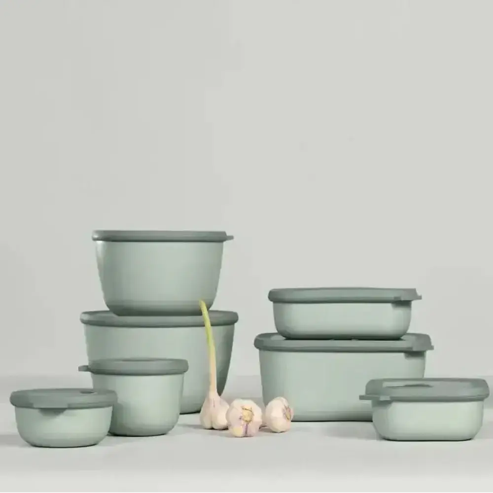 Set of green food storage containers on a light gray background
