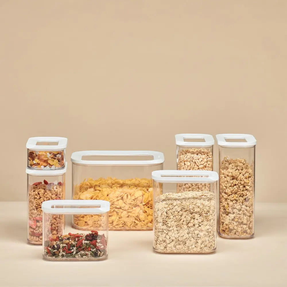 Set of five plastic storage containers with lids on a beige background