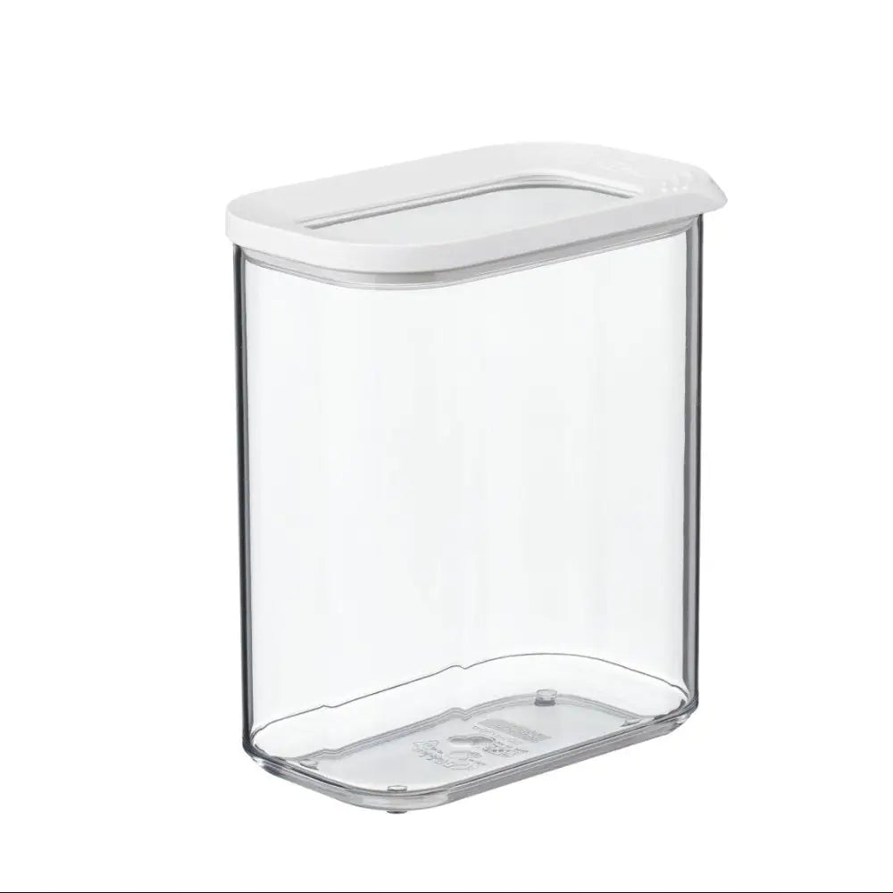 Clear container with red lentils on a wooden surface, surrounded by other jars.