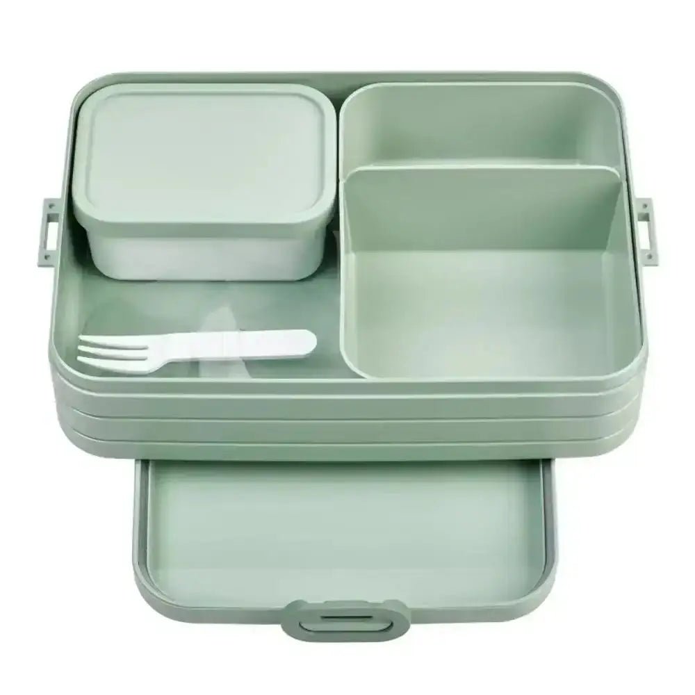 Green lunch box with compartments and utensils on a white background