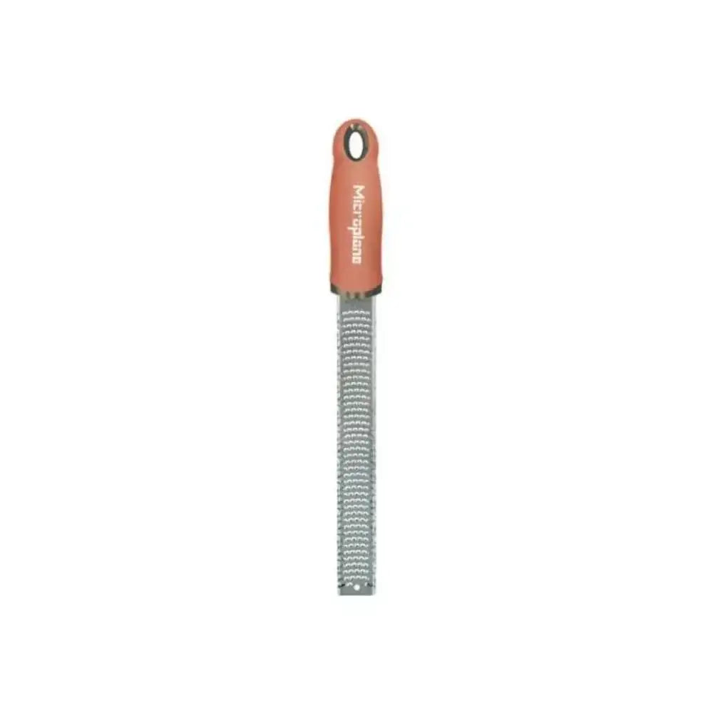 Metal zester with orange handle on a white background