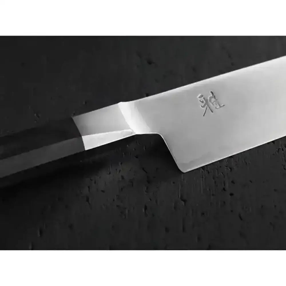 Close-up of a chef's knife with a brand logo on a dark surface