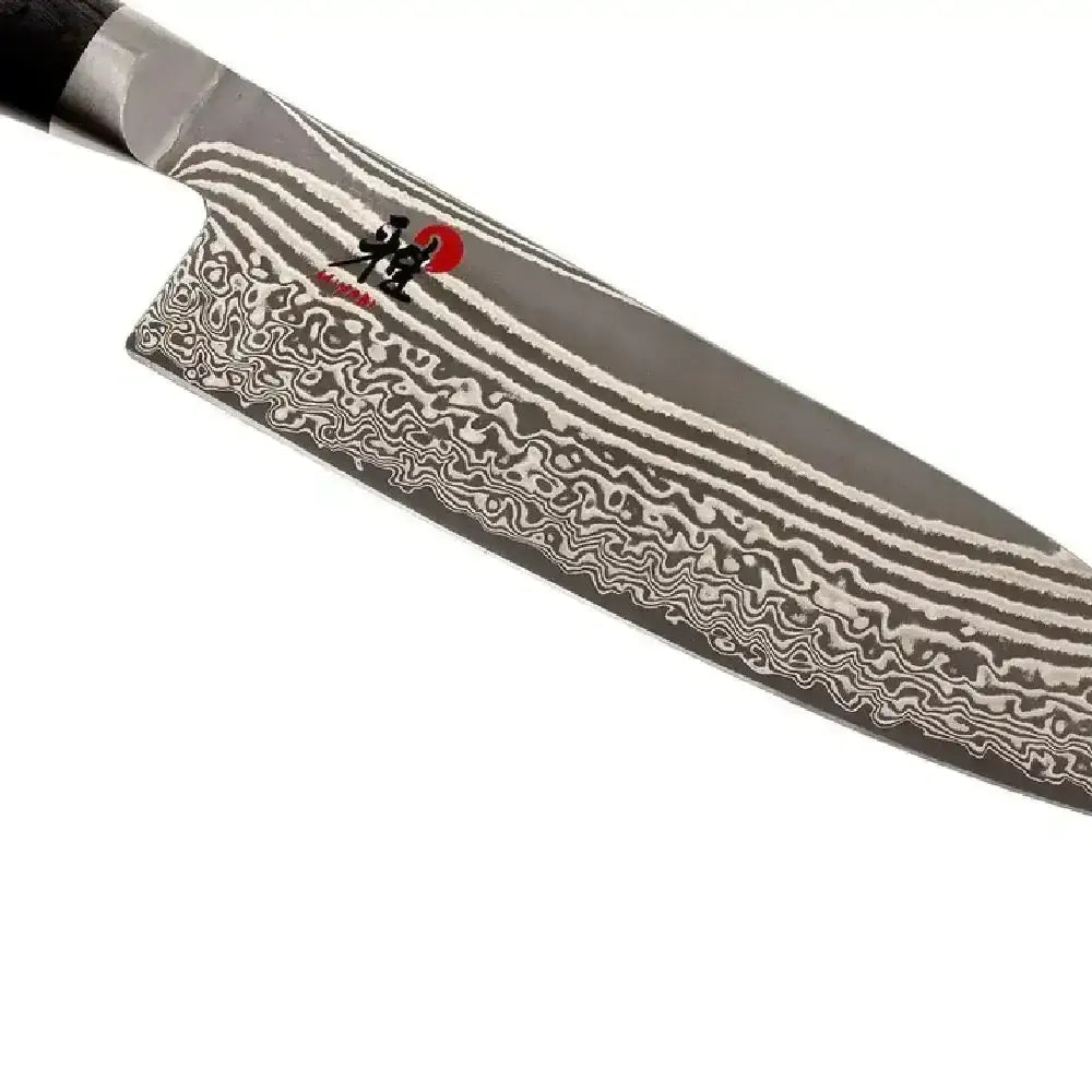 Damascus-patterned knife blade on a white background