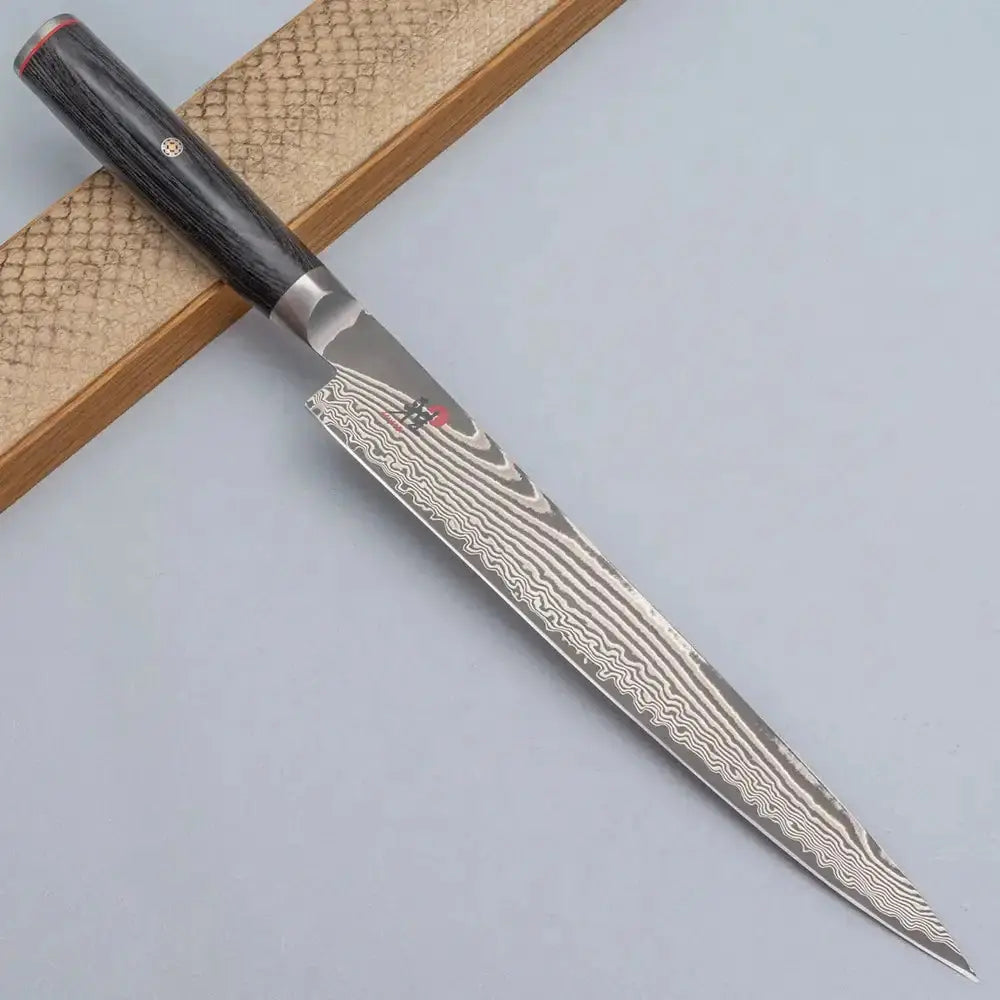 Knife with Damascus steel blade on a textured surface