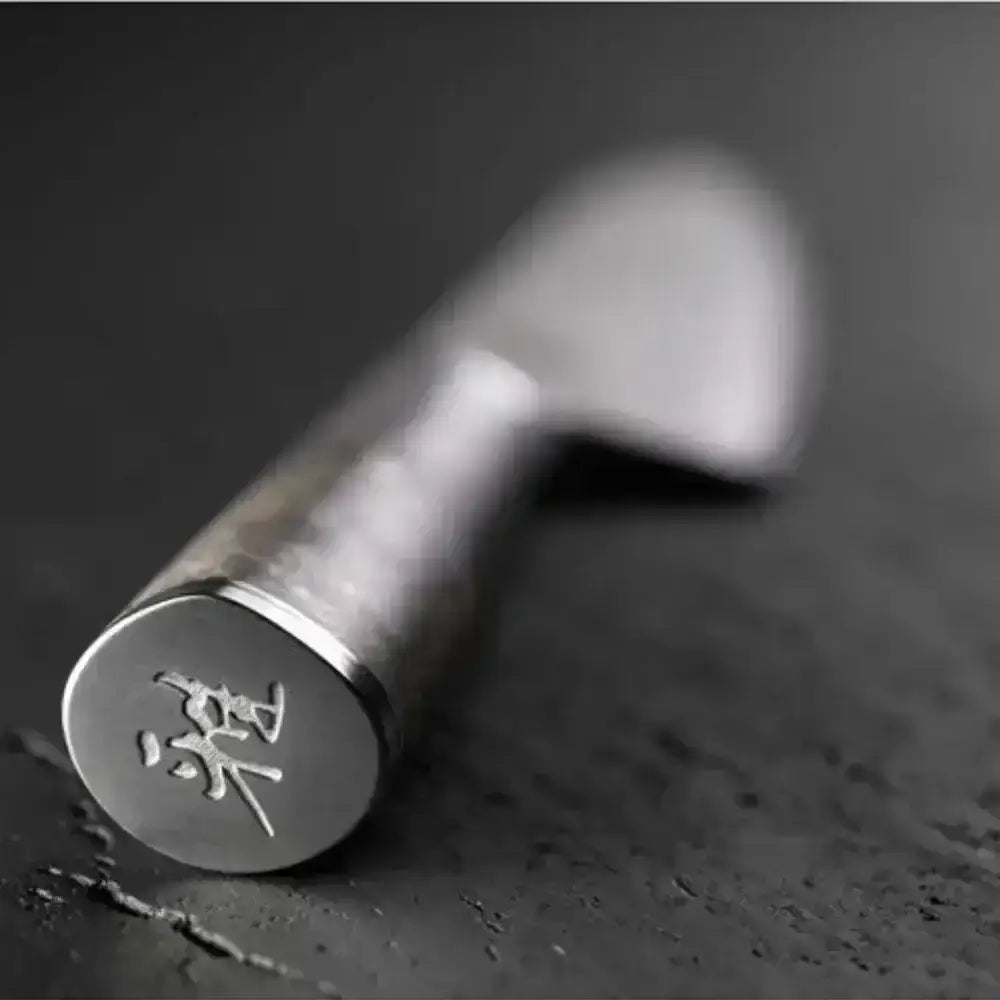 Metallic tool with engraved characters on a dark surface