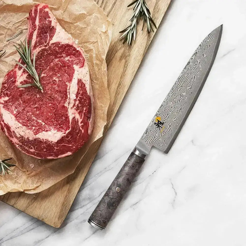Steak on parchment paper with a knife on a marble surface