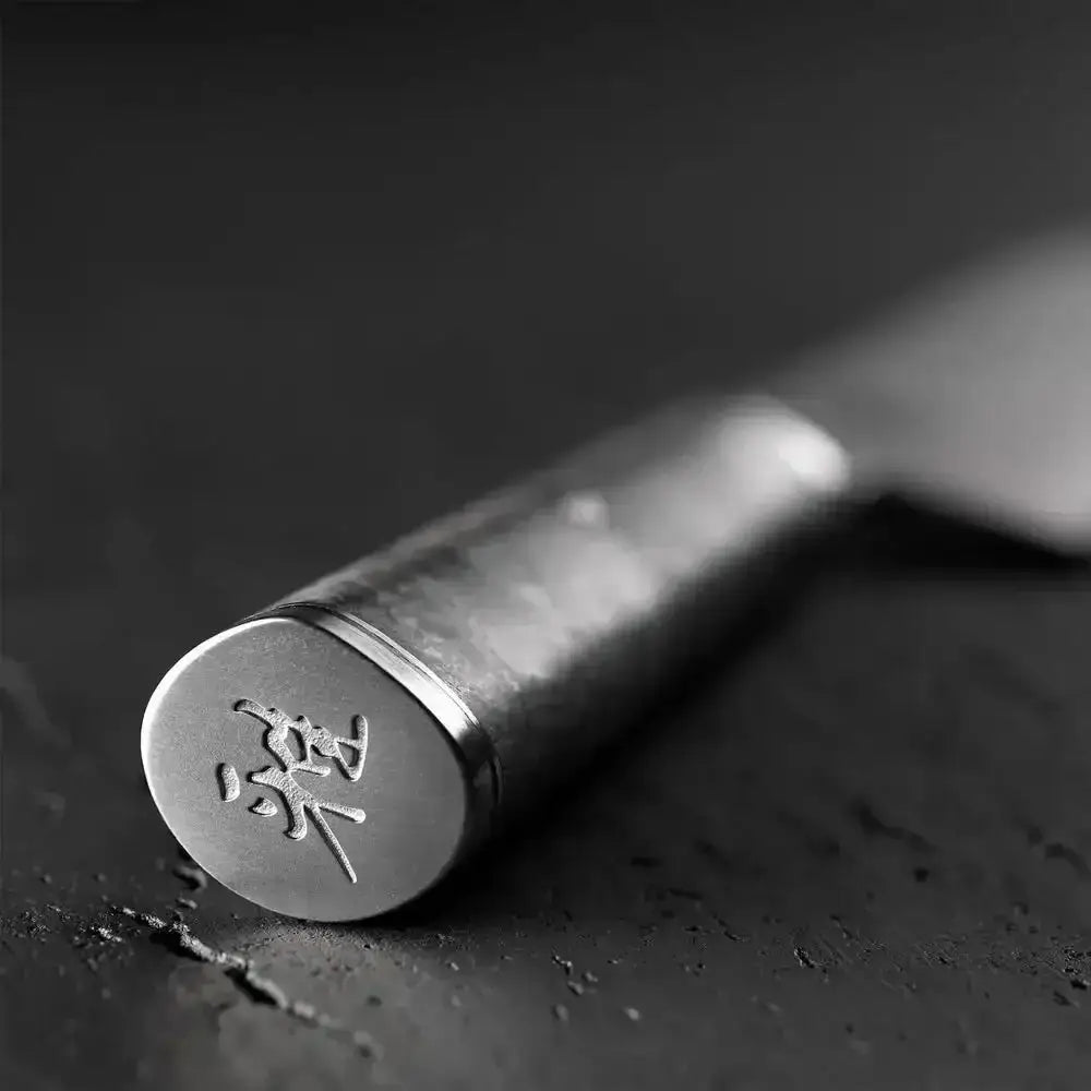 Metallic tool with engraved characters on a dark surface