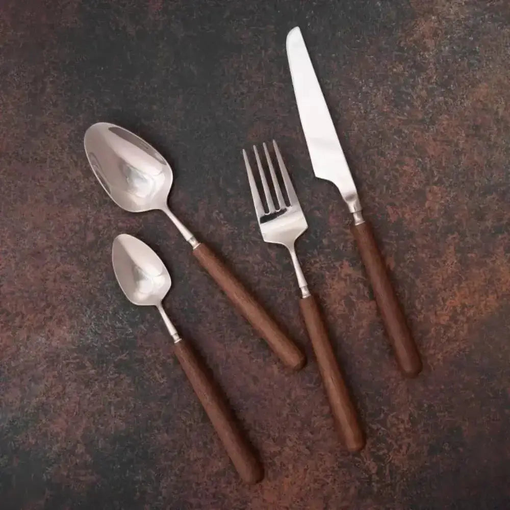 Set of silver cutlery with brown handles on a dark surface
