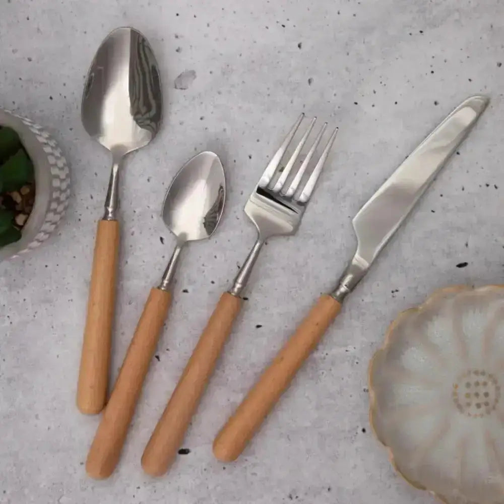Set of silver cutlery with wooden handles on a gray surface