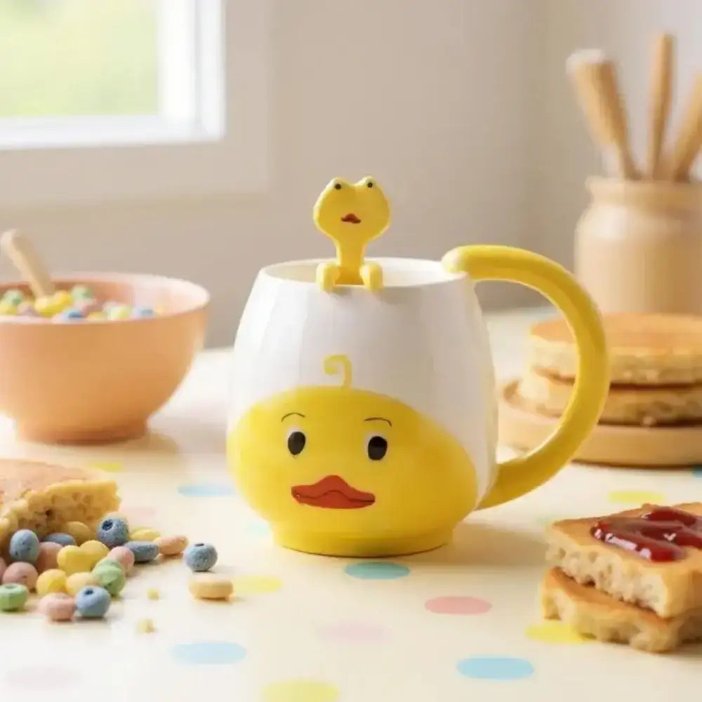Yellow duck-shaped mug with a matching spoon on a breakfast table.