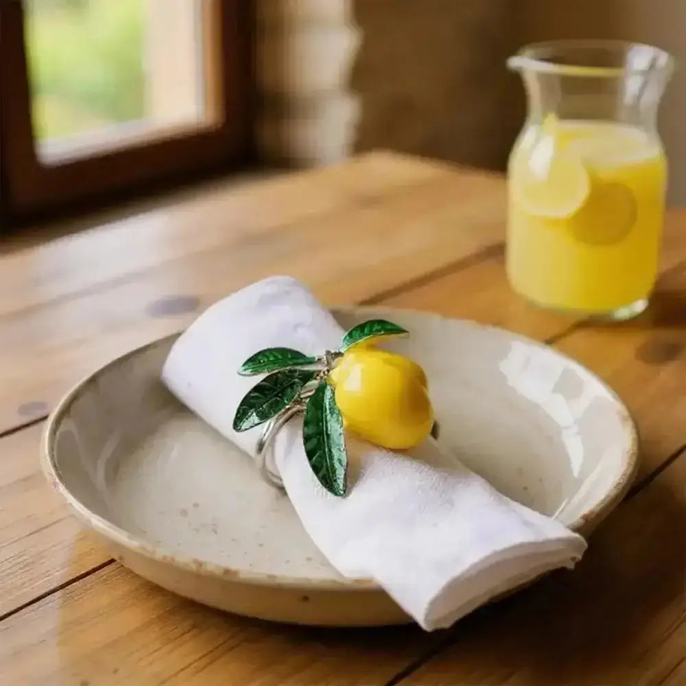 Heart-shaped ceramic plate with a folded white napkin, lemon decor, and a glass of orange juice on a wooden table.