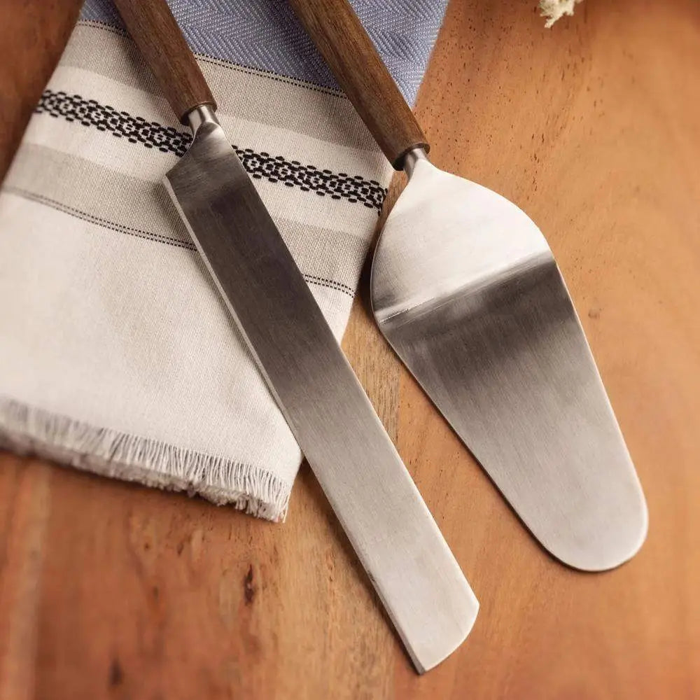 Two metal spatulas with wooden handles on a wooden surface.