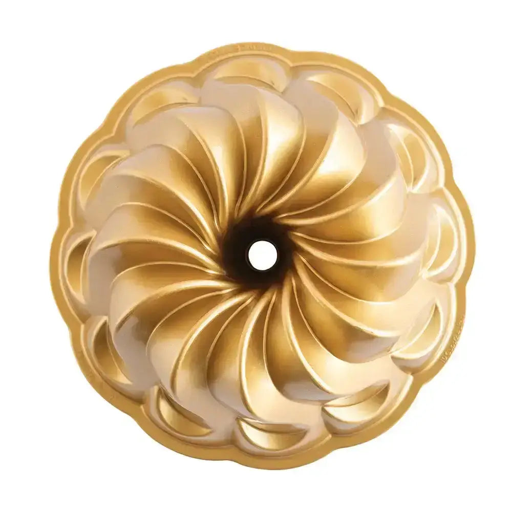Gold decorative object with a spiral design on a white background