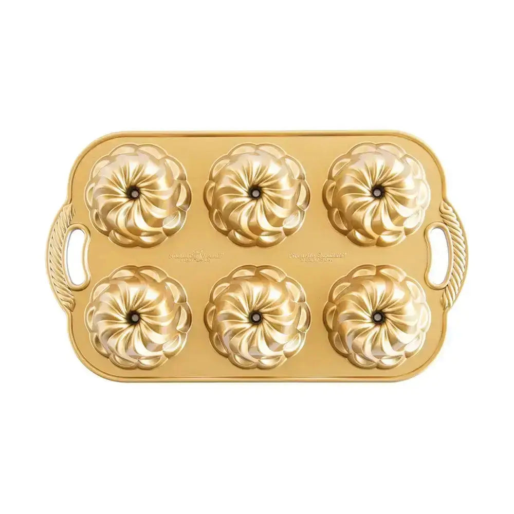 Gold muffin tin with decorative design on a white background