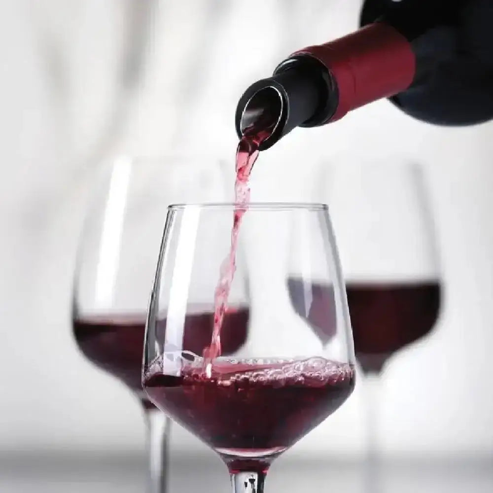 Red wine being poured into a glass with a blurred background