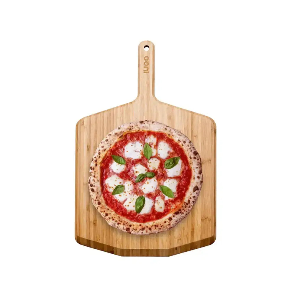 Wooden pizza peel with a pizza on a white background