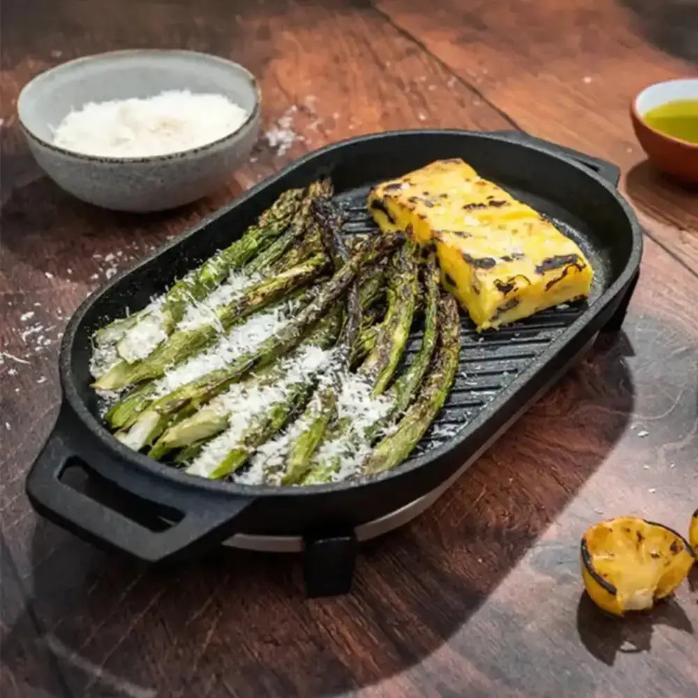 Grilled vegetables and tofu on a black grill pan on a wooden table.