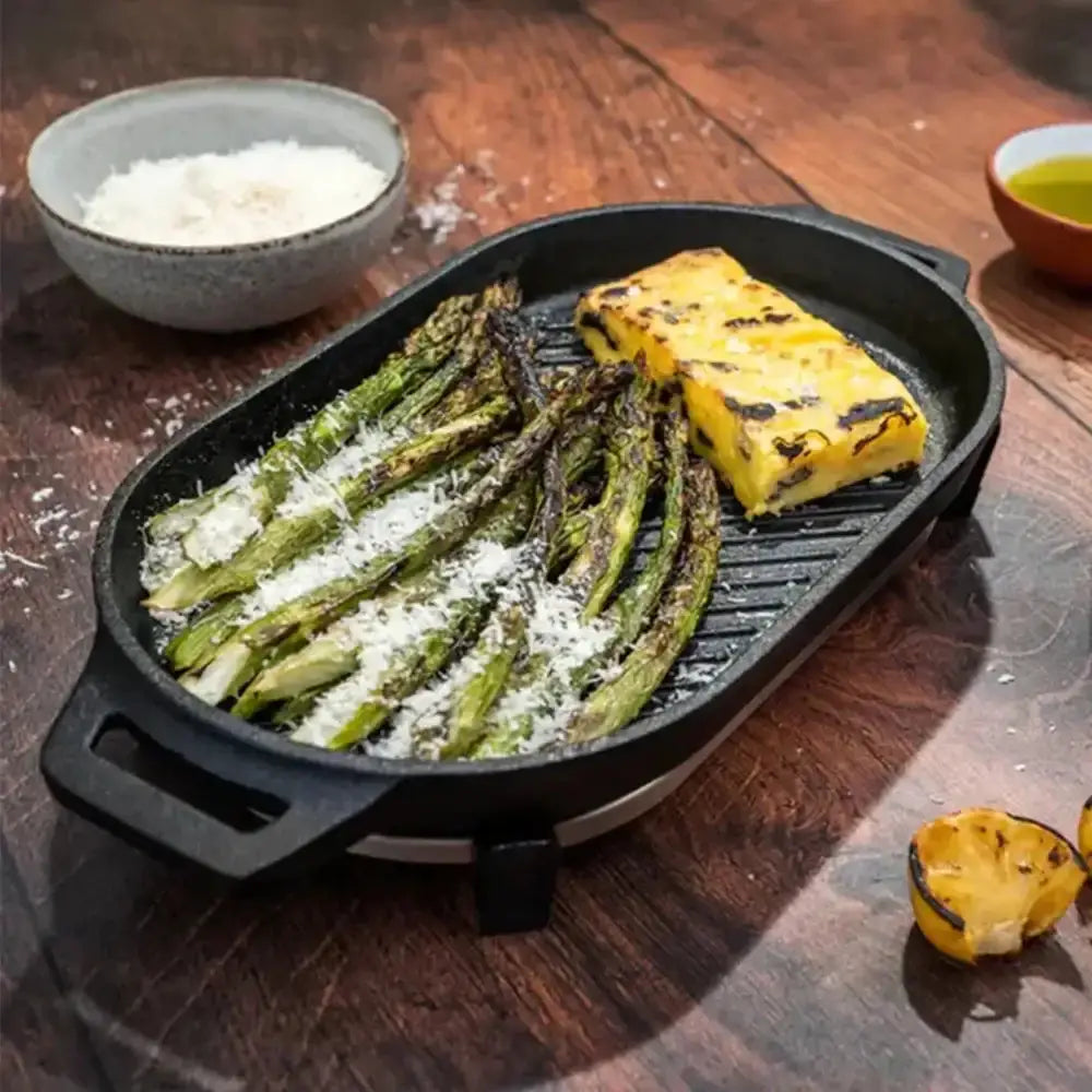 Grilled vegetables and tofu on a black grill pan on a wooden table.