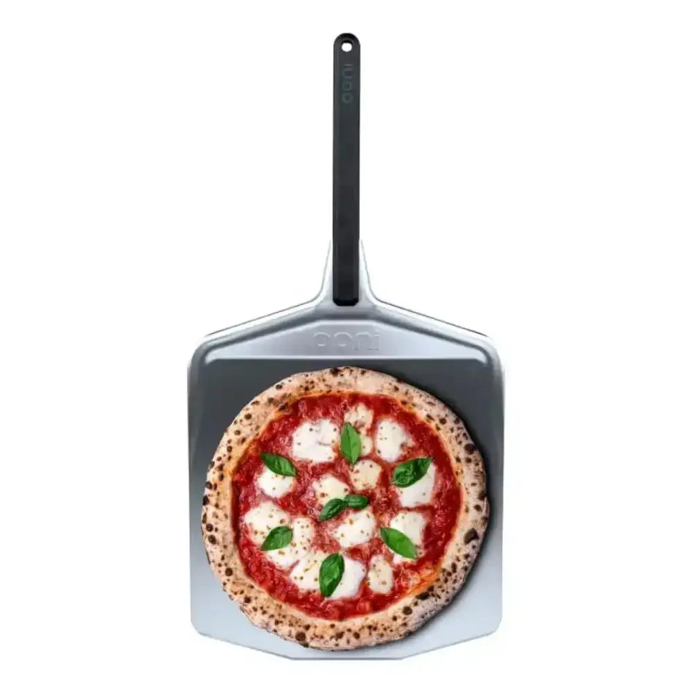 Pizza on a metal pizza peel with a white background