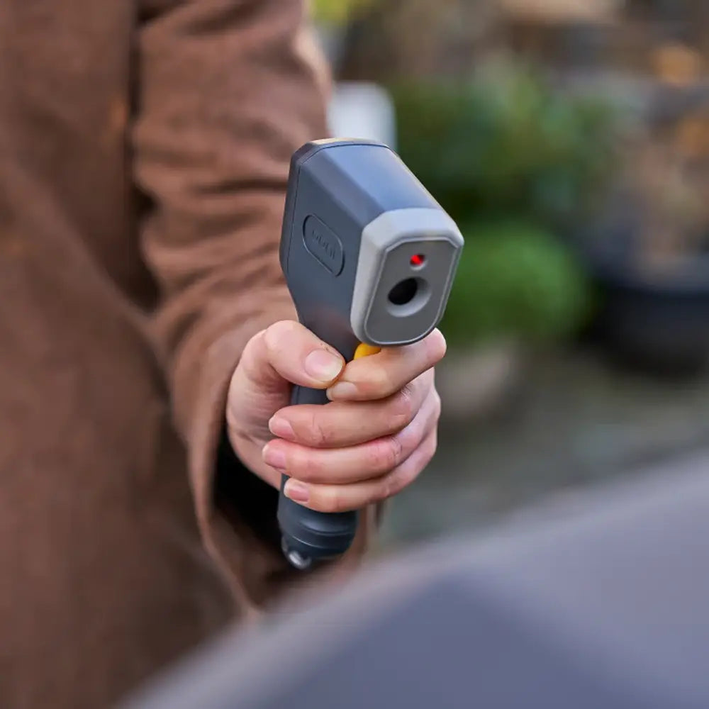Hand holding a thermal imaging device with a blurred background