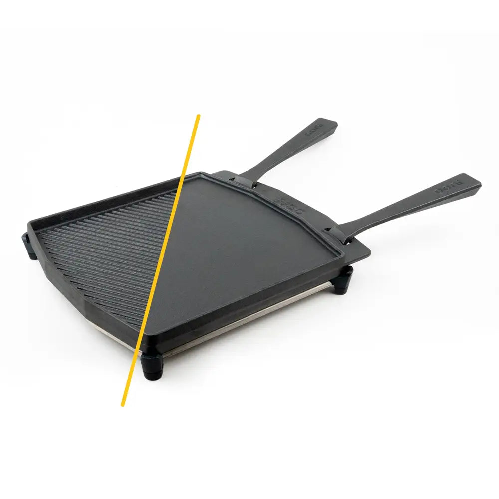 Black cast iron grizzler plate with ribbed surface and two handles for use with pizza ovens and stainless steel trivet