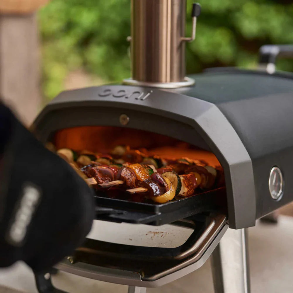 Ooni pizza oven with food inside, outdoor setting