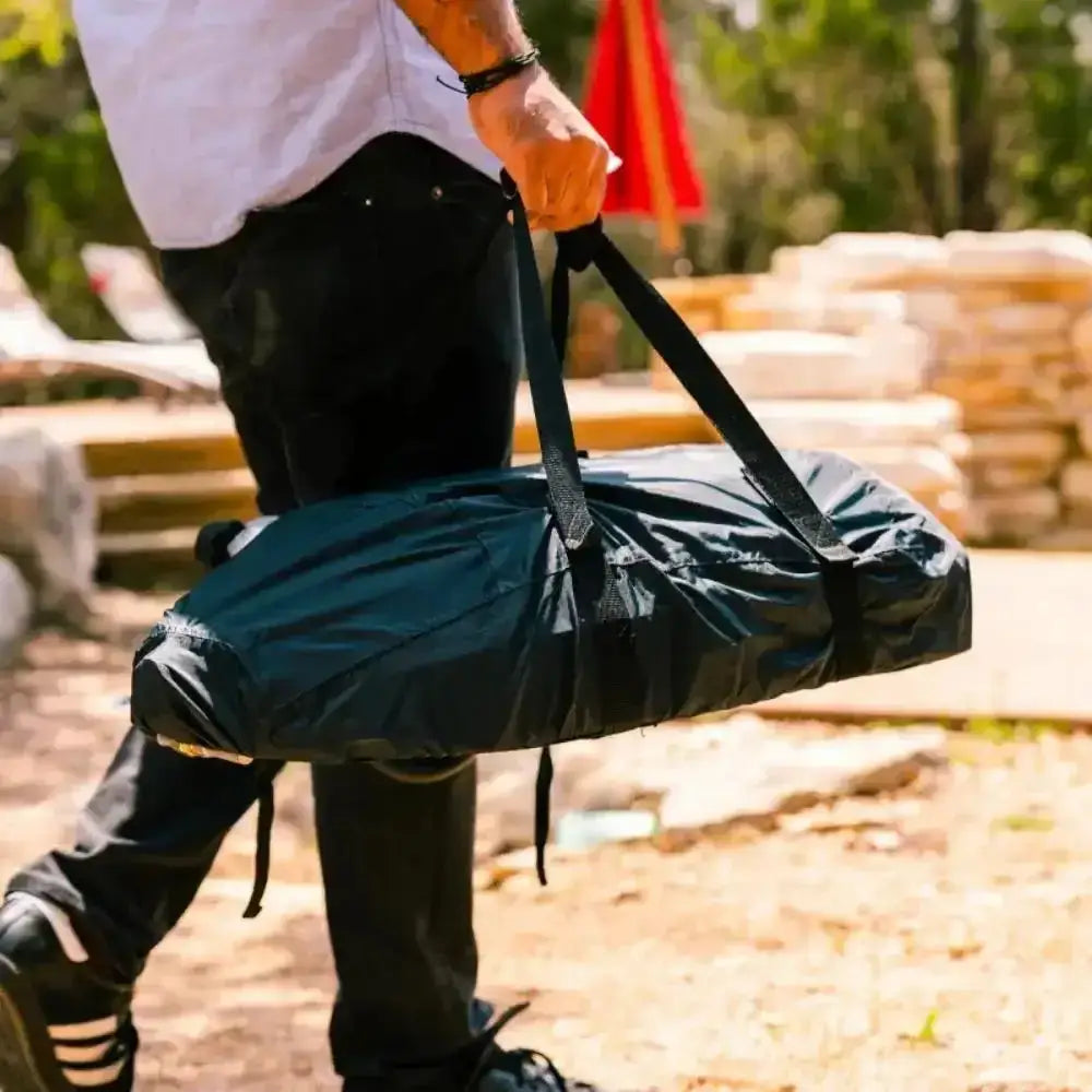Person holding a bag with a blurred outdoor background