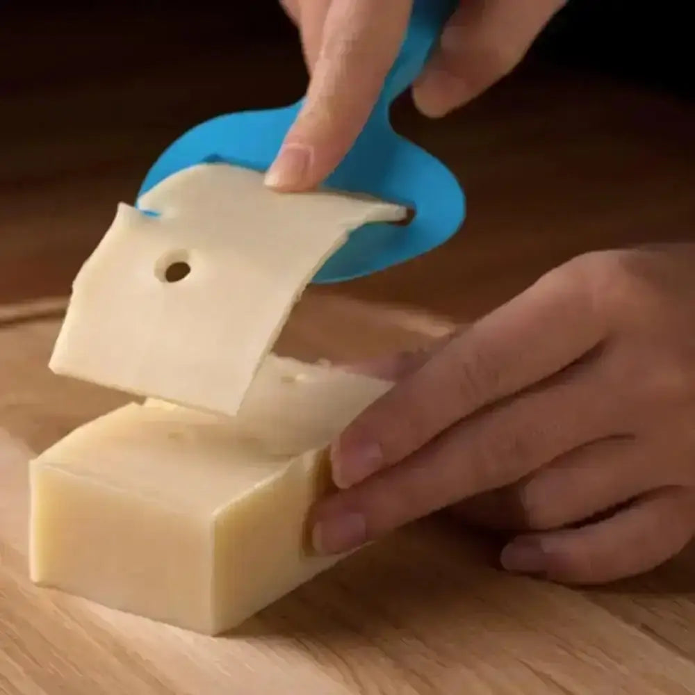 Person using a blue soap cutter to slice a bar of soap on a wooden surface