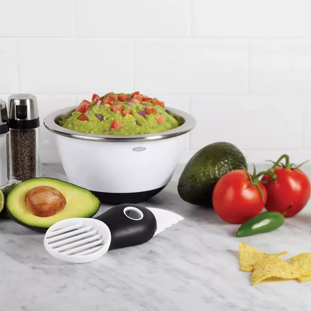 Oxo avocado slicer with vegetables and bowl with crushed avocado 