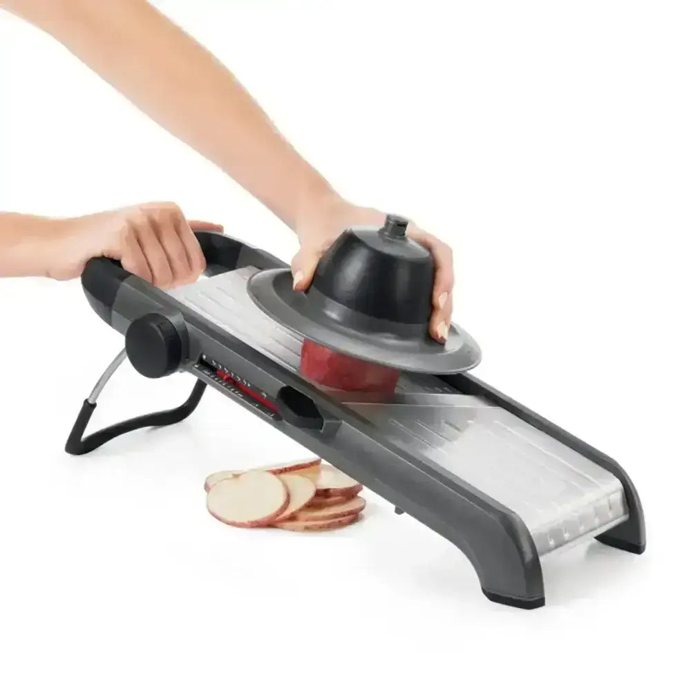 Veggie peeler with sliced apples on a white background