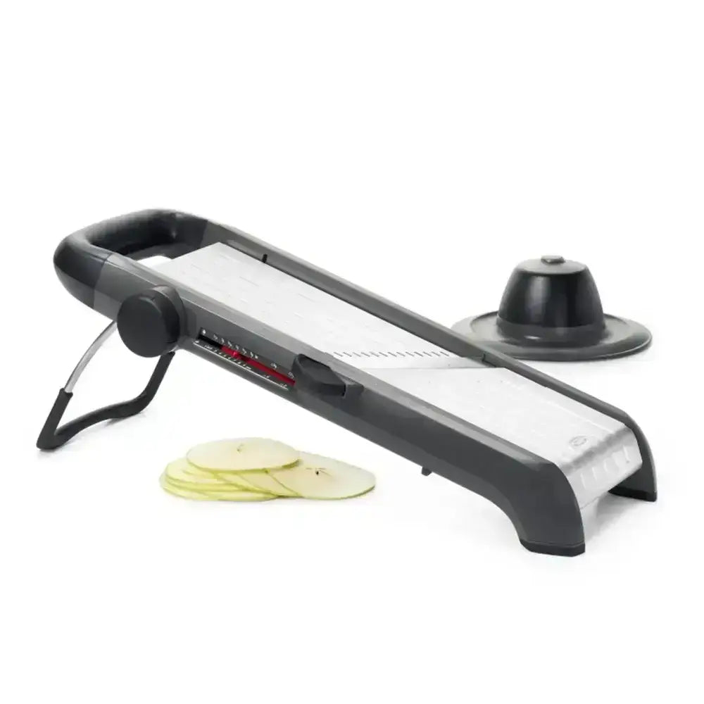 Black and silver mandoline slicer with sliced vegetables on a white background