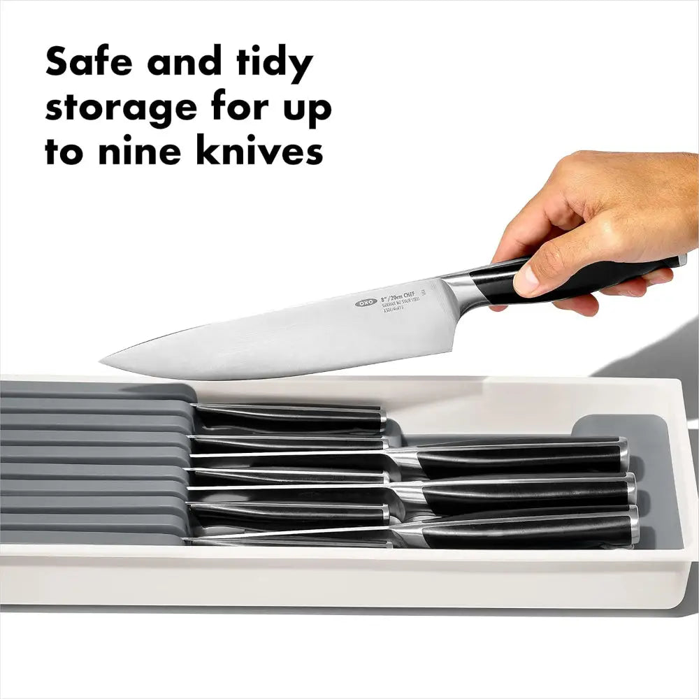 Oxo good grips knife drawer organizer with black-handled stainless steel knives in a white good grips compact block