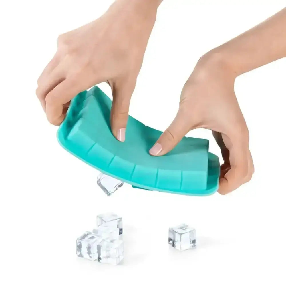 Teal ice cube tray with hands lifting a clear ice cube out of it on a white background