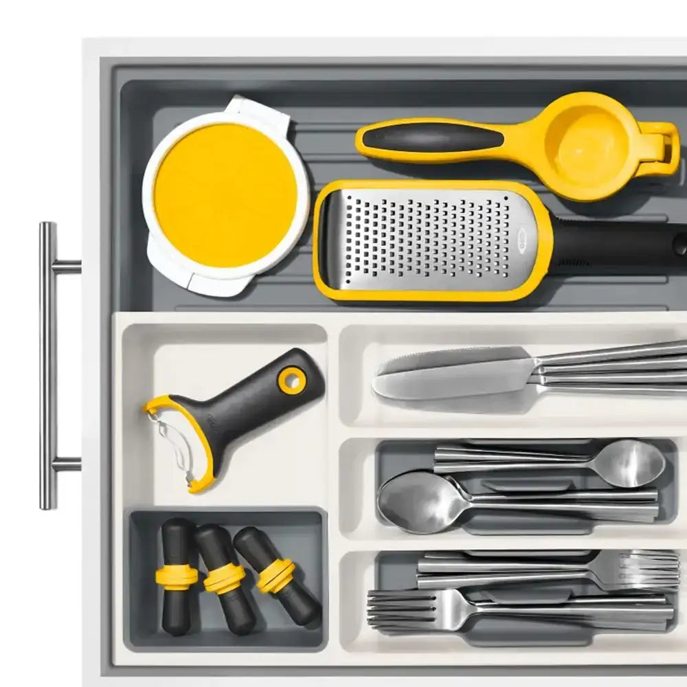 Set of kitchen utensils including a grater, spoon, and other tools in a drawer.