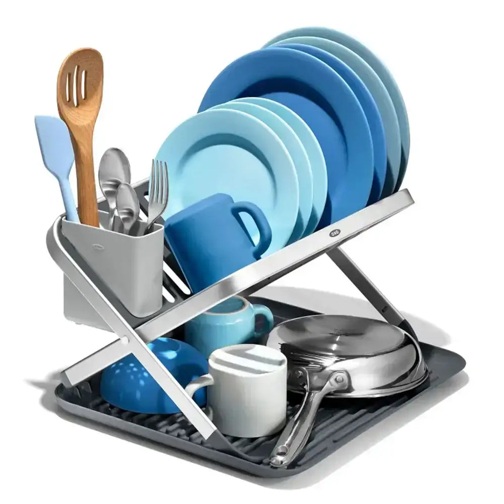 Dish rack with blue dishes, silverware, and cookware on a white background
