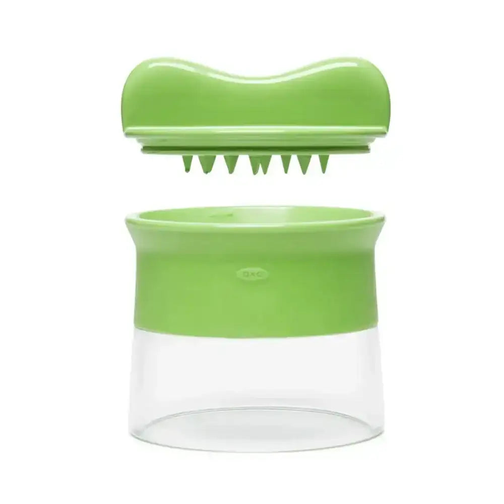 Green kitchen tool with a clear container on a white background