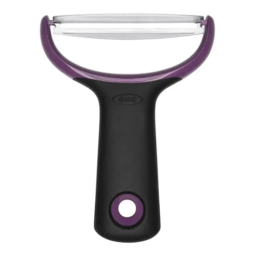 Oxo vegetable peeler with purple handle and blade on a white background