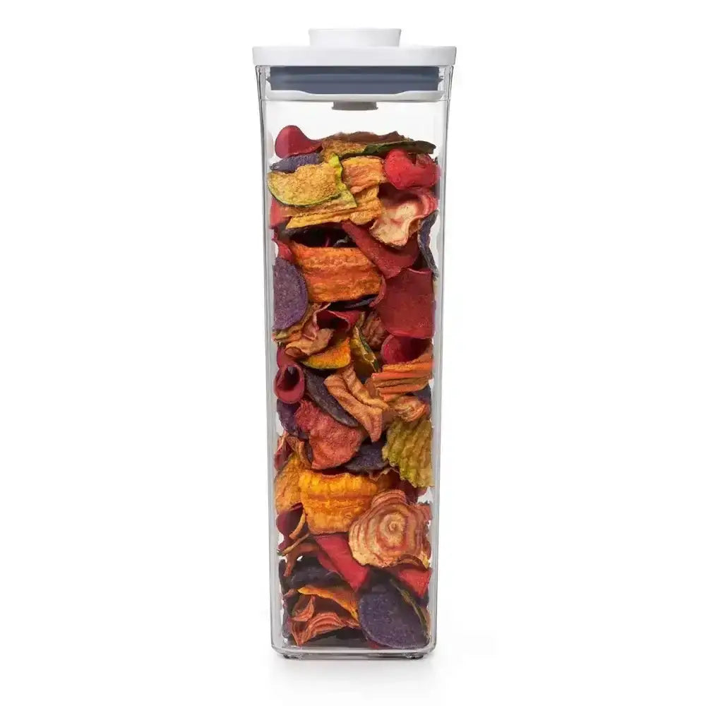 Clear container filled with colorful dried fruit on a white background