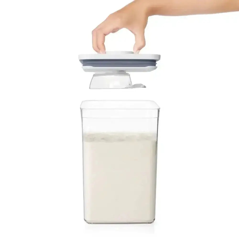 Container with a hand placing a lid on it, filled with a white substance.