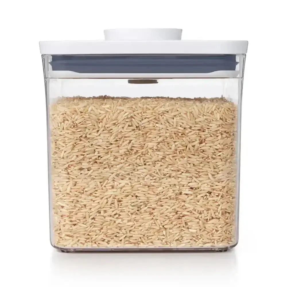 Clear container with lid filled with rice on a white background
