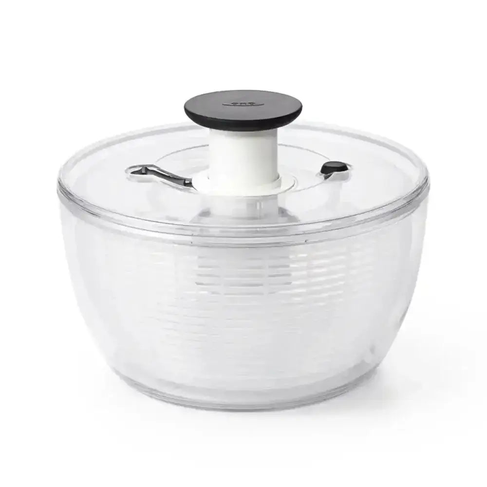 Clear salad spinner with black lid on a white background