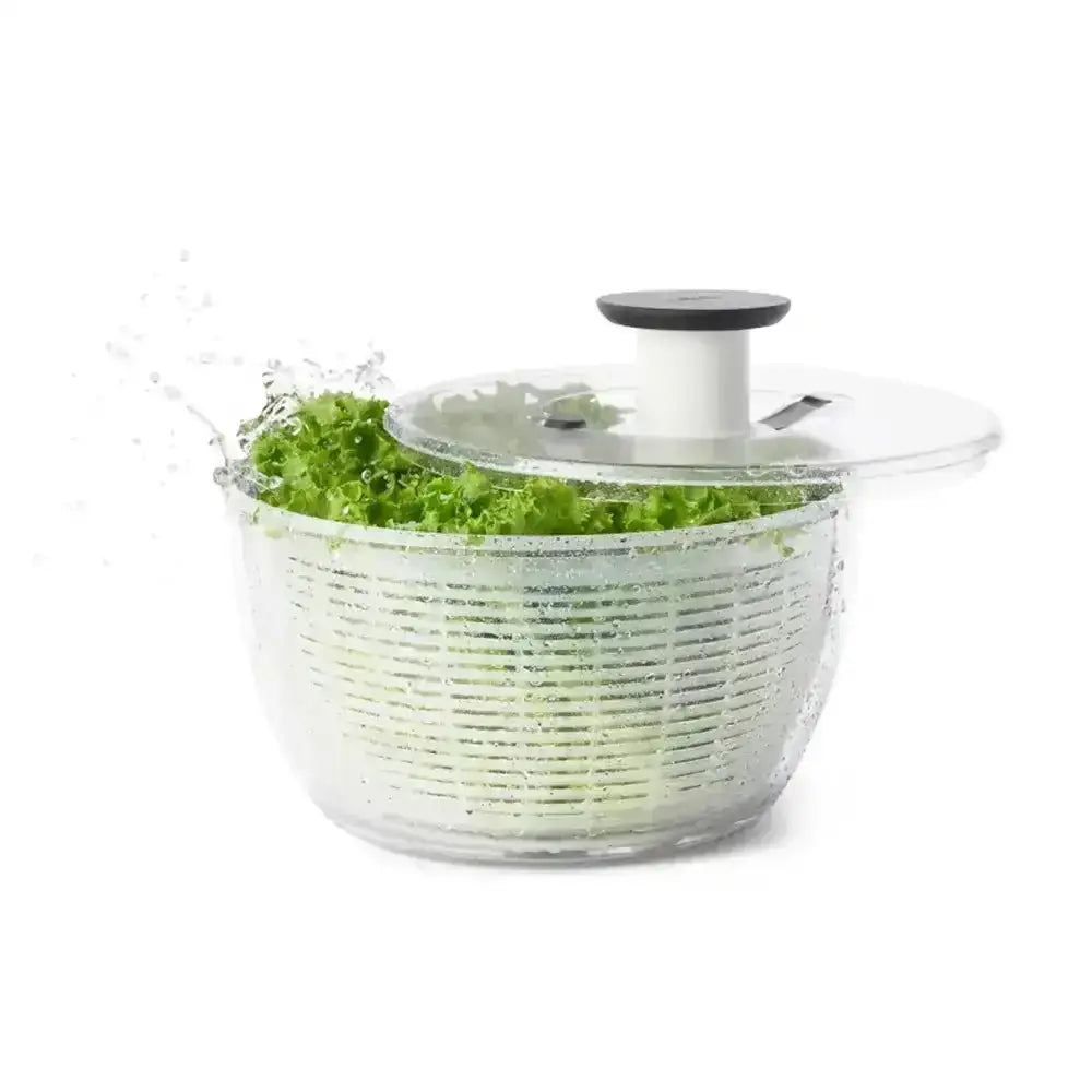 Clear salad spinner with green lettuce on a white background