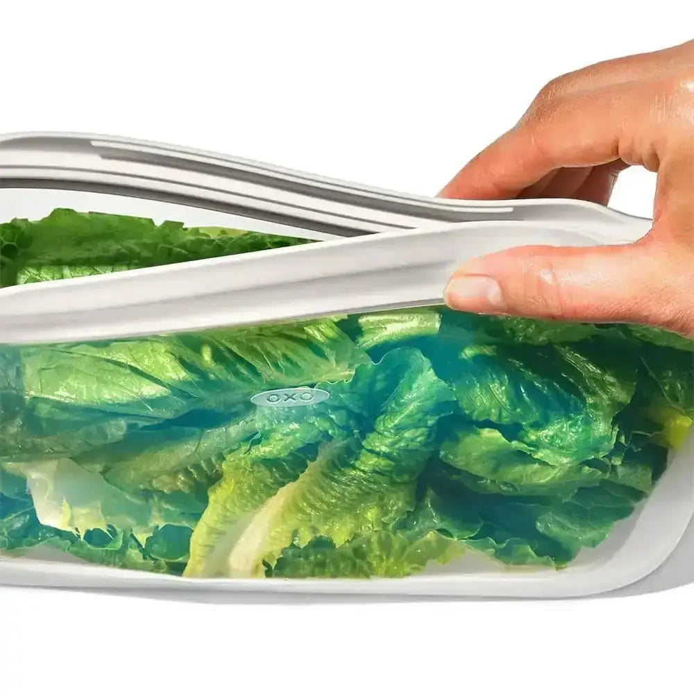Oxo good grips silicone flat reusable food storage bag 1.8l filled with green lettuce for kitchen use