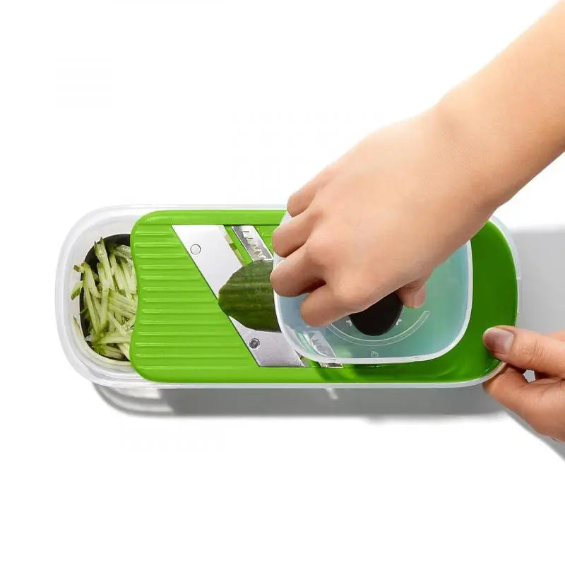 Someone using the vegetable slicer on a white background