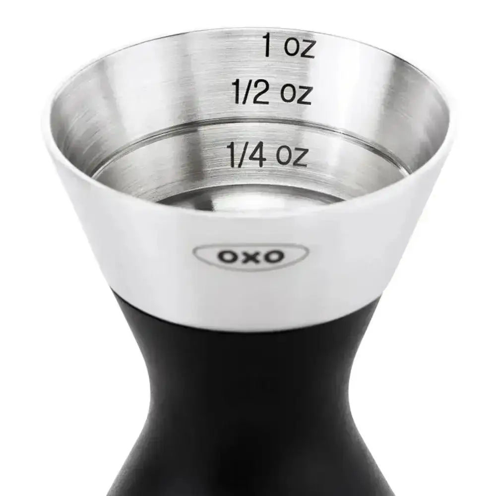 Metal jigger with measurements on a white background
