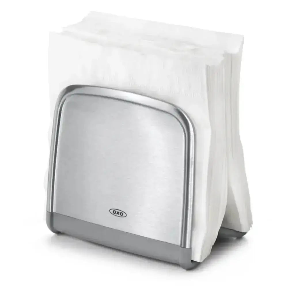 Metallic napkin holder with a stack of white napkins on a white background