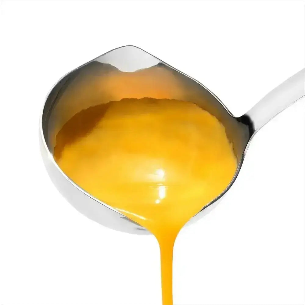 Oxo good grips stainless steel soup ladle pouring golden yellow liquid from its spout with a shiny finish