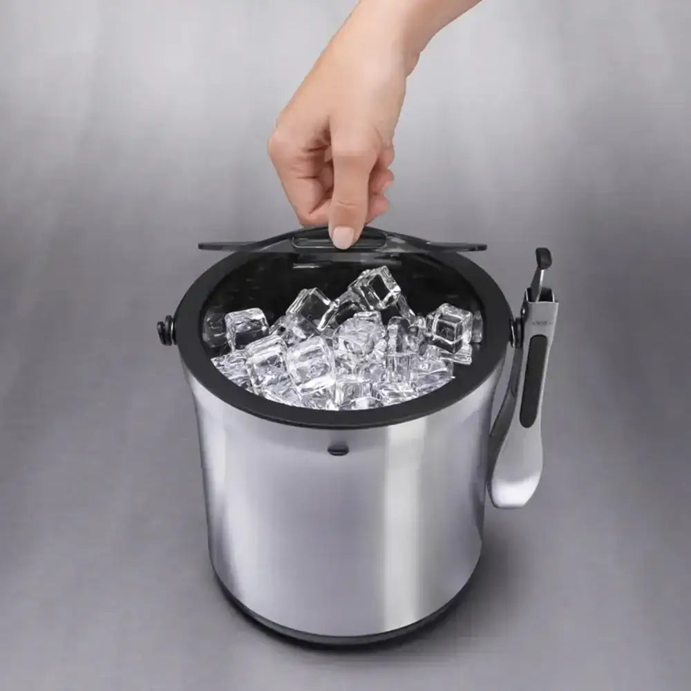 Stainless steel ice bucket with ice cubes on a gray background